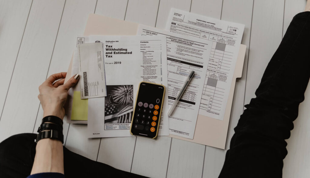 hand holding tax papers with calculator