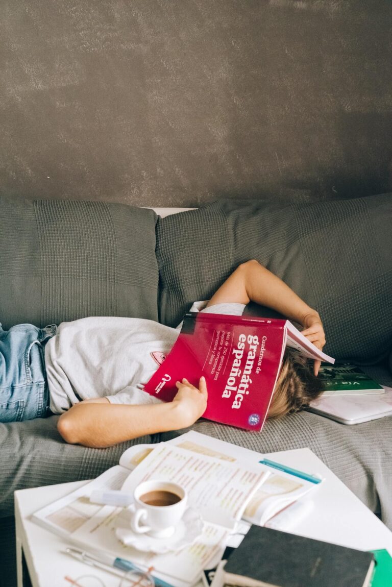 Student covering face with Spanish book.